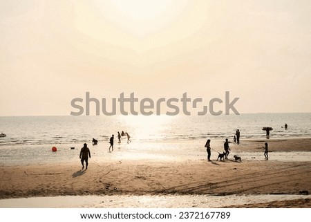 Beach during sunset in Thailand. many people are activity on the beach at sunset. In front of them and watching the sun set over the ocean. Silhouettes in the sunset at the beach.