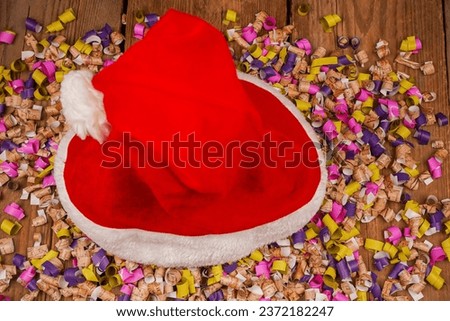 Top view photo of Christmas Flatlay gift box and Christmas tree decorations. Santa hat on a wooden backgroundon. Christmas background with place for text. Copyspace. Christmas tree toys