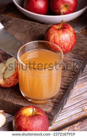 Healthy organic home made  Apple cider vinegar in glass and fresh red apples on a dark background.