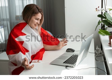 female student sitting with canadian flag and using laptop 
