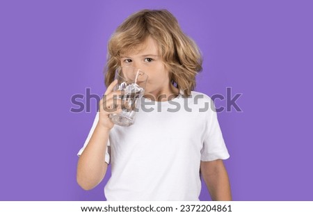 Kid drinking water, isolated on studio background. Portrait of little child with glass of fresh water. Thirsty kid. Refreshing. Water balance. Portrait of kid drinking pure water. Royalty-Free Stock Photo #2372204861