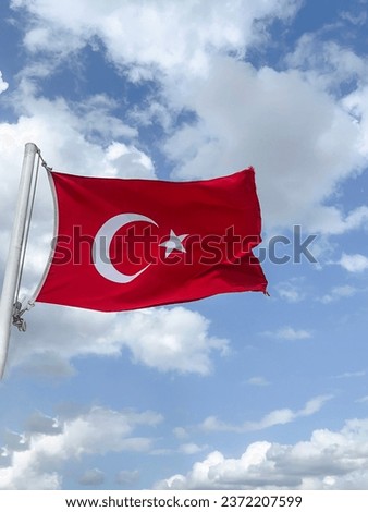Turkish flag, side view Turkish flag waving in the air with selective focus over beautiful blue sky and white clouds in a beautiful sunny day. symbol of Turkey. Republic of Turkey or Turkiye landmark