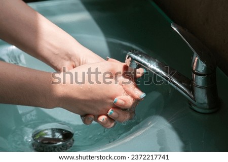 Wash your hands using hand sanitizer to kill germs that you might accidentally touch, such as the COVID-19 virus, before working or eating or doing other activities. Royalty-Free Stock Photo #2372217741