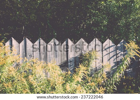 old wooden fence with barbed wire on top - retro, vintage style look