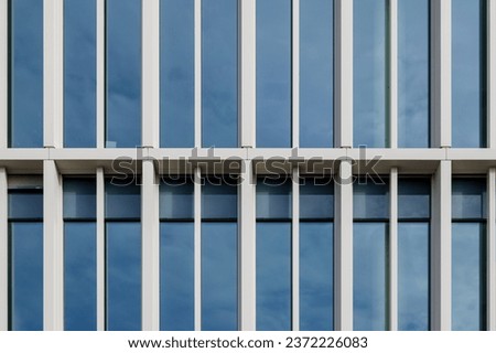 Outdoor exterior front view of modern facade with typical rectangular modern narrow vertical windows. Royalty-Free Stock Photo #2372226083