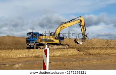 Highway construction. Excavator leveling ground on Roadworks. Roadway Work Safety. Road reconstruction and repair. Excavator during road work at construction site. Screeding gravel for laying asphalt 