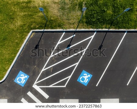 Aerial image looking straight down over two handicap, ADA, parking stalls. Royalty-Free Stock Photo #2372257863