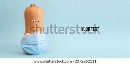Pumpkin with eyes and medical mask on blue background. Medicine, quarantine, halloween concept. Copy space