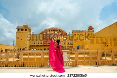 Woman in side the Hawa Mahal, also known as the Palace of the Wind, in the pink city of Jaipur in Rajasthan, India. Royalty-Free Stock Photo #2372280865