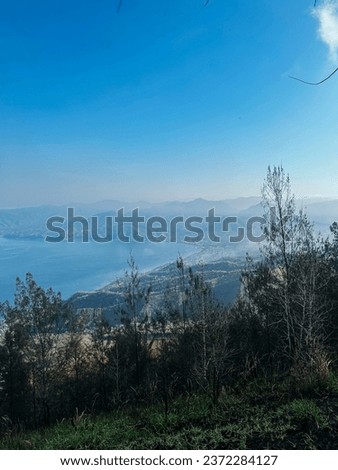 beautiful natural scenery in the morning, mist covering the mountains and the sky is blue and clean, cool air, shady trees on the mountain, peaceful atmosphere in the morning, 