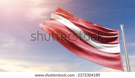 Latvia  national flag waving in beautiful sky. The flag waving with dynamic angle.