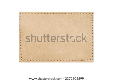 Brown suede belt strap closeup isolated on white. Brown stitched leather seam frame label tag. Empty copy space fashion background. Stitch patch cutout. Royalty-Free Stock Photo #2372305599
