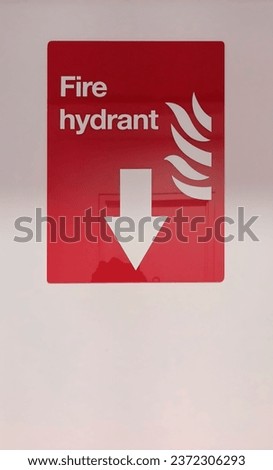 Fire hydrant nameplate made of acrylic mounted on a white wall as a background to give the information location of fire extinguishers with red and white font color.