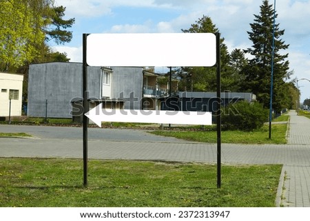 Empty signboard with arrow outdoors. Mock-up for design