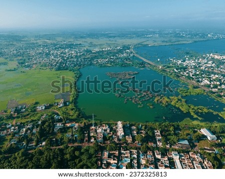 drone shot aerial view top angle panoramic photograph of lake pond reservoir dam turquoise blue water scenery mangrove forest cityscape rainwater flood monsoon township india madurai Tamilnadu sunny 