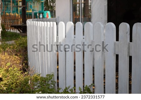 White wooden fence in a children's park on a clear sunny day