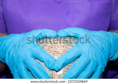 nurse hands with blue surgical gloves forming a heart " america " Royalty-Free Stock Photo #2372334869