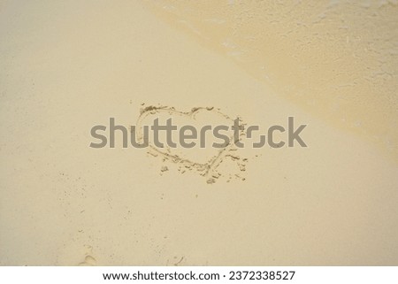 Heart shape drawn on sand on the beach. Space for text. 