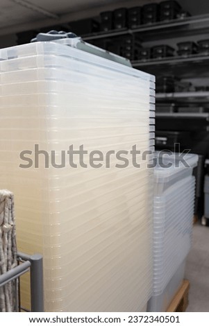 Plastic containers. A lot of white plastic containers are stored on wooden pallets.