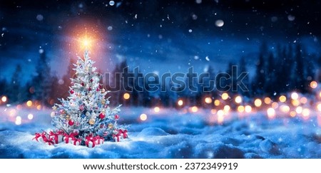 Christmas Tree And Gift Boxes On Snow In Night With Shiny Star and Forest - Winter Abstract Landscape Royalty-Free Stock Photo #2372349919