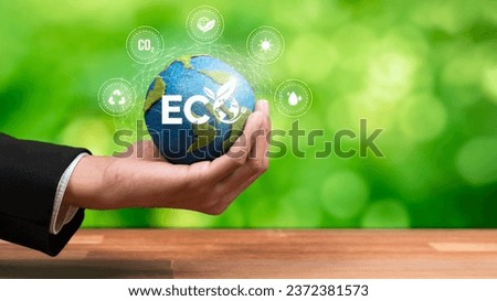 Businessman's hand holding Earth globe symbolize corporate commitment to ESG to reduce carbon emission, adopt eco friendly clean business to minimize environmental impact for net zero world. Reliance Royalty-Free Stock Photo #2372381573