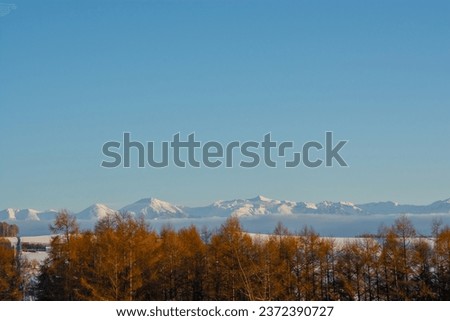 Beautiful winter landscape with snow-capped mountains and blue sky