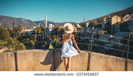 Woman in white dress looking at Old mosque in Town of Mostar- Bosnia Herzegovina Royalty-Free Stock Photo #2372426837