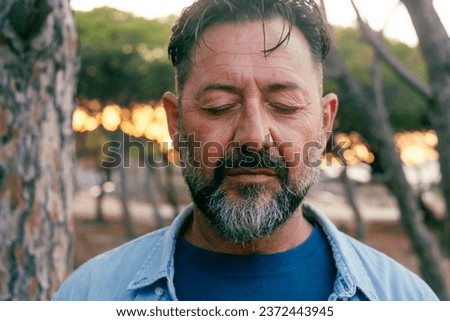 Close up Sad man portrait expression face close up in outdoor park. One adult mature male people with closed eyes . Problems on life. Mental burnout. Depression and therapy. Life trouble person Royalty-Free Stock Photo #2372443945