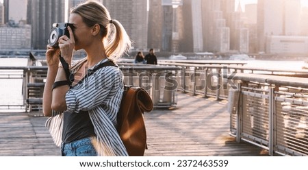 Side view of skilled female traveller testing camera during journey trip