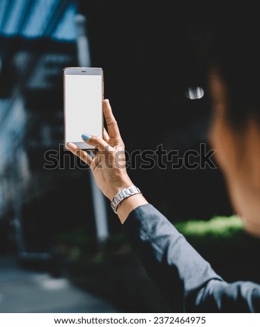Woman taking picture of city with cellphone