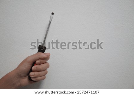 Human hand holding a wrench isolated on white background. Closeup. High resolution product. The mechanic's hand holds a wrench behind himself. Mechanic holding wrench for car repair