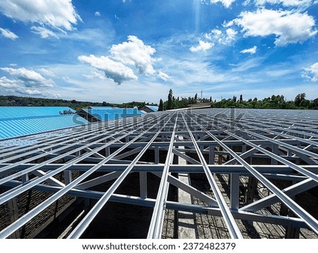 light steel roof frame of an elementary school, under a cloudy blue sky Royalty-Free Stock Photo #2372482379