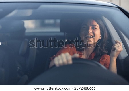 Photo of positive cheerful girl funky driver rider enjoy drive ride car under pop star hits playlist music try dance raise hands in city center