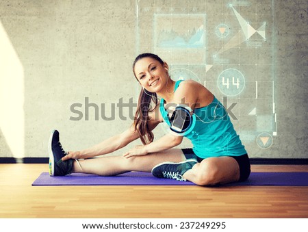 fitness, sport, training, future technology and lifestyle concept - smiling woman stretching leg on mat in gym over graph projection