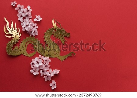 Paper cut-out dragon with plum blossoms on red card. Copy space. Top view. Chinese New Year.