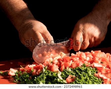 A chief is chopping tomatoes for making salad to serve as sidebar with Adana kebap Royalty-Free Stock Photo #2372498961