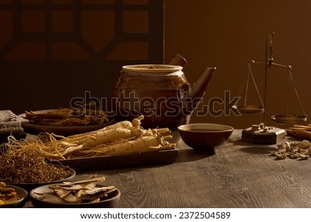 Scenes of many oriental medicines are displayed on a wooden background, decorated with medicine pot, bowl and a small ancient scale. Background for advertising with the concept of folk medicine Royalty-Free Stock Photo #2372504589