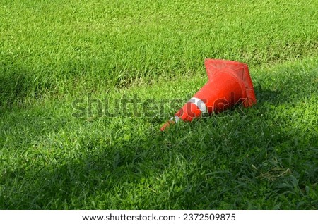road marker traffic cone rubber cone on green field Royalty-Free Stock Photo #2372509875