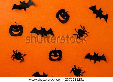 Halloween background, paper black bats, pumpkins and spiders on orange paper. Background for advertising.