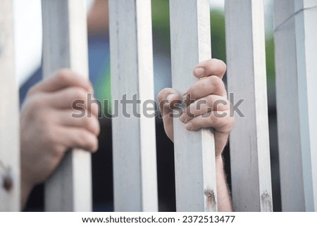 prisoner looking out of the window of a prison cell Royalty-Free Stock Photo #2372513477