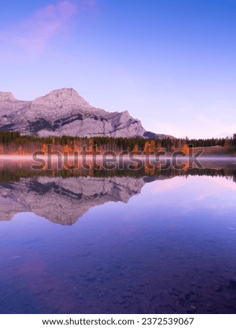 Mountain landscape at dawn. Foggy morning. Lake and forest in a mountain valley at dawn.Reflections on the surface of the lake. Wedge Pond, Banff National Park, Alberta, Canada. 