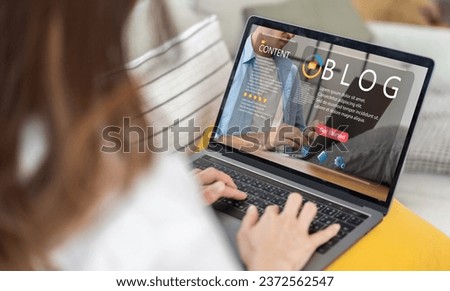 Woman ues laptop computer with social media online content, freelance worker, working online, content creator, blogger, technology, website, woman reading blog online on computer at home Royalty-Free Stock Photo #2372562547