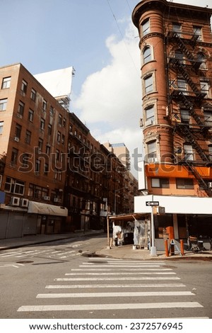 vintage building with fire escape stairs near pedestrian crossing on street corner in new york city Royalty-Free Stock Photo #2372576945