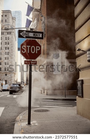 steam near traffic signs on roadway of avenue in downtown of new york city, metropolis environment