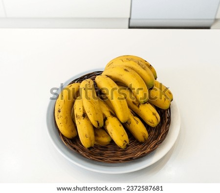 A bunch of fresh banana lie on the table in a modern kitchen, healthy life concept.