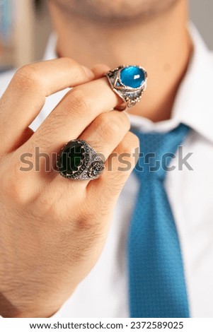 Elegantly dressed businessman and man jewelry concept.
Charismatic man showing silver ring.