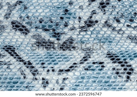 Snakeskin pattern on genuine leather close-up, imitation of exotic reptile, trendy background