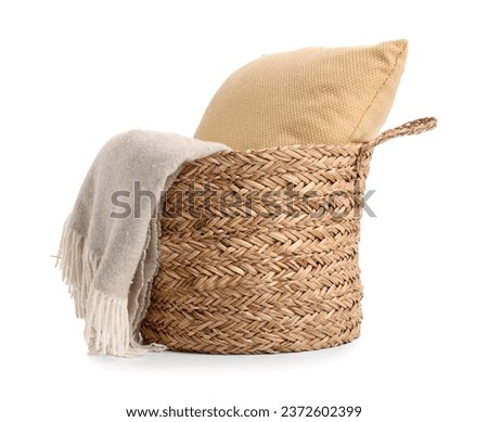 Wicker basket with cushion and blanket isolated on white background Royalty-Free Stock Photo #2372602399