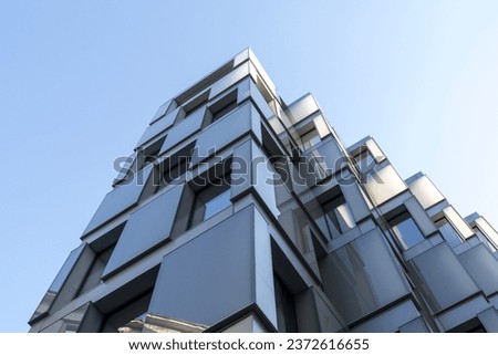 The exterior of the clubhouse with a facade of translucent frosted glass . The aesthetics of minimalism in architecture . Simple shapes , clear lines and unusual geometry . A modern unique building . Royalty-Free Stock Photo #2372616655