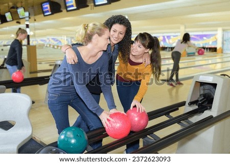 portrait of girlfriends collecting bowling balls